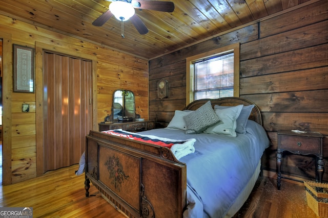 bedroom with wood-type flooring, ceiling fan, wooden walls, and wood ceiling