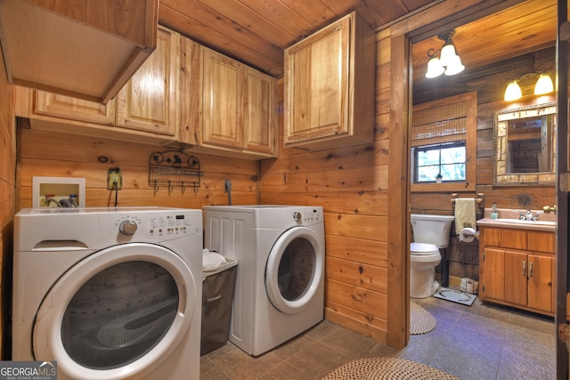 laundry room with sink, cabinets, washing machine and dryer, wooden walls, and wood ceiling