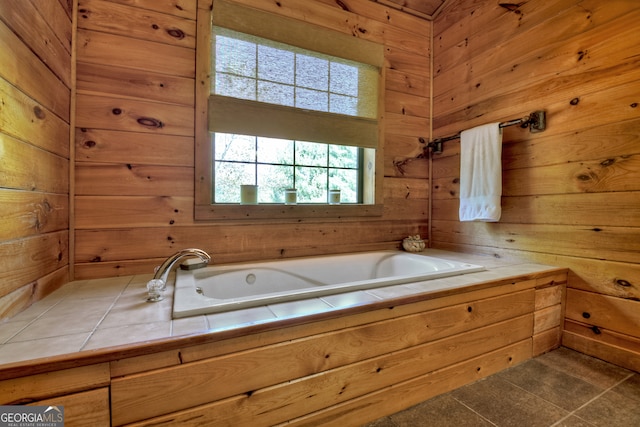 bathroom featuring wooden walls, tile patterned flooring, and a bathtub