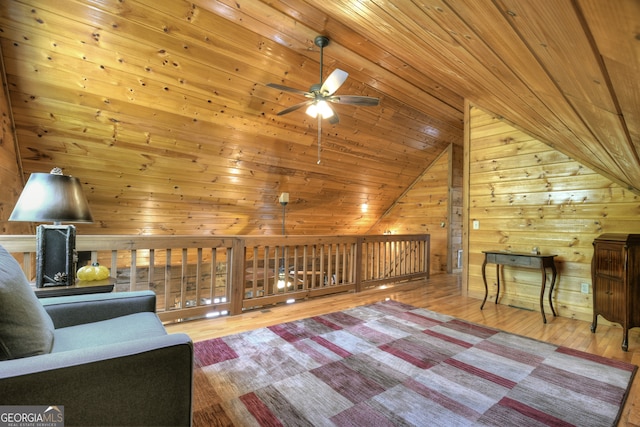 unfurnished room featuring ceiling fan, wooden ceiling, wood-type flooring, vaulted ceiling, and wooden walls