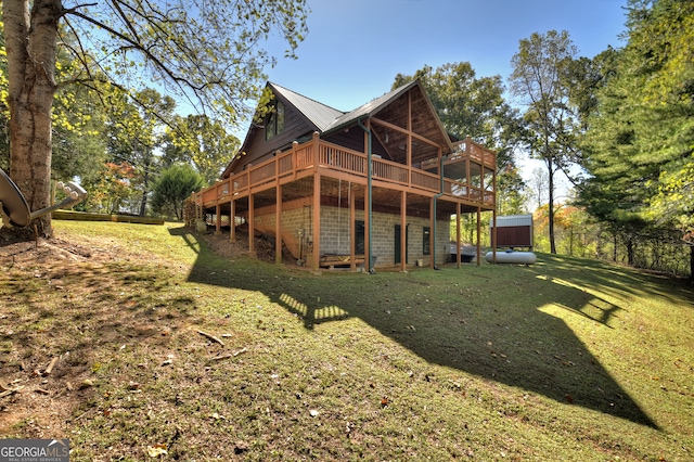 rear view of house with a yard and a wooden deck