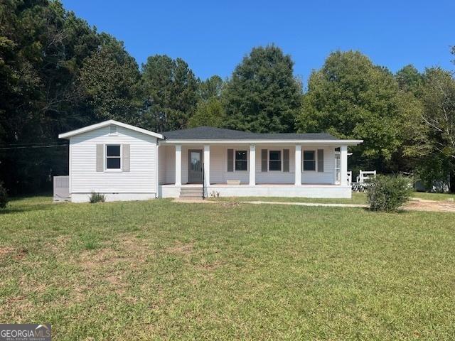 ranch-style house with covered porch and a front yard