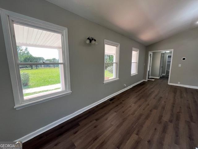 unfurnished living room with vaulted ceiling with beams, a notable chandelier, and dark hardwood / wood-style floors