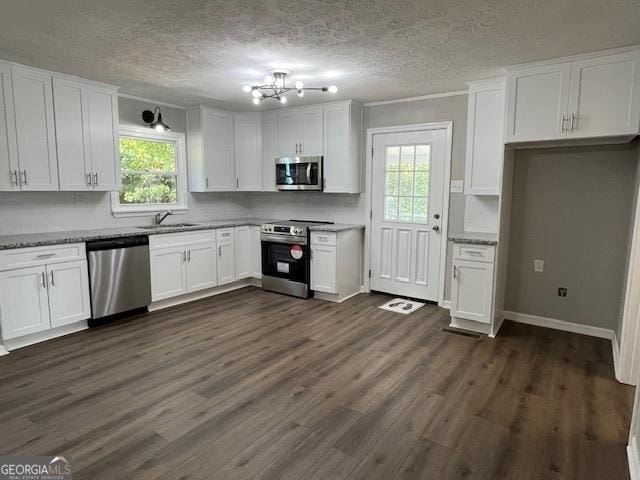 kitchen with dark wood-style flooring, white cabinets, appliances with stainless steel finishes, and a sink