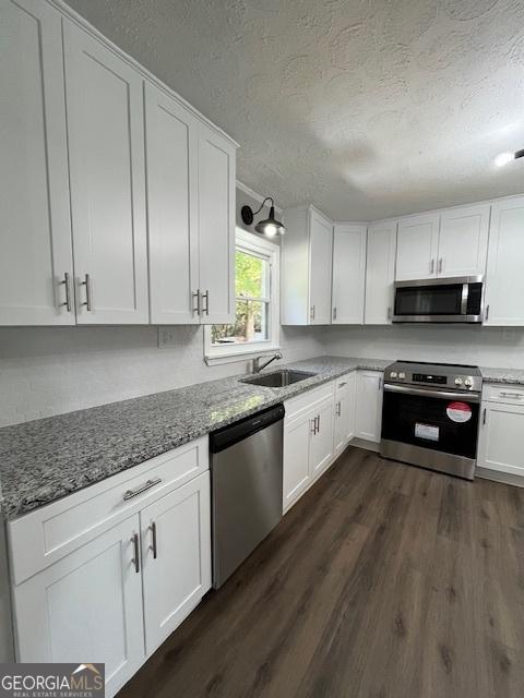 kitchen with white cabinetry, dark wood-type flooring, and appliances with stainless steel finishes