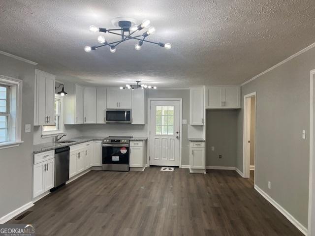 kitchen with light stone counters, appliances with stainless steel finishes, dark hardwood / wood-style flooring, and white cabinets