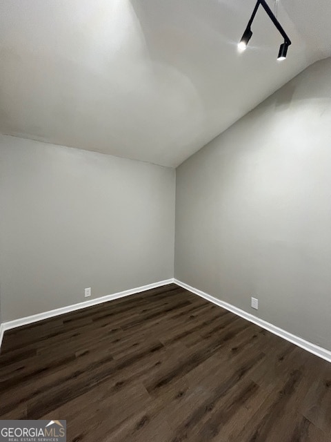 additional living space with dark wood-type flooring and vaulted ceiling