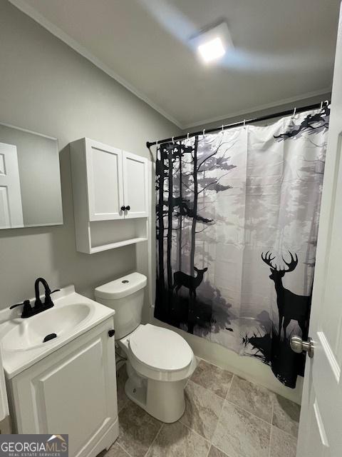 bathroom with curtained shower, vanity, and toilet