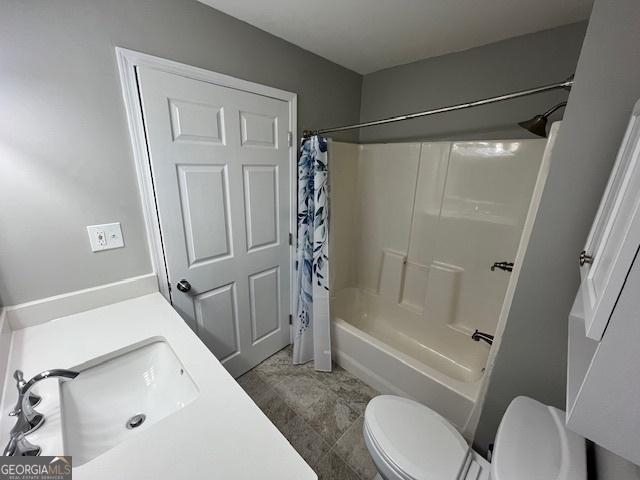 bathroom with a sink, shower / bathtub combination with curtain, and toilet