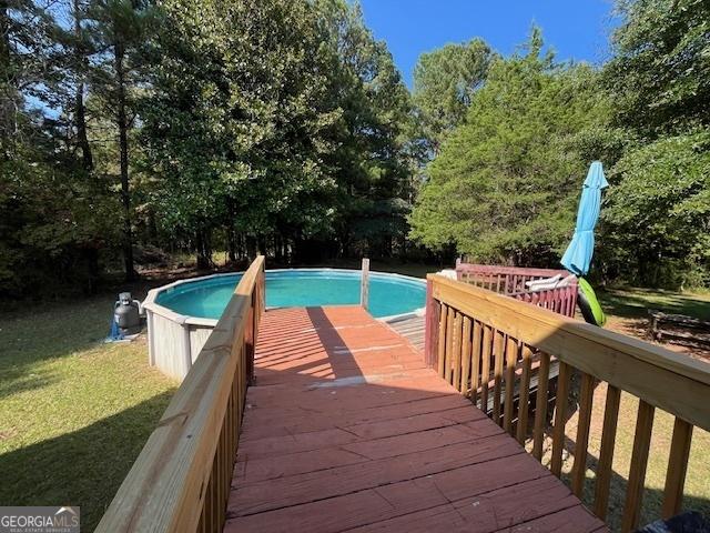 pool featuring a yard and a deck