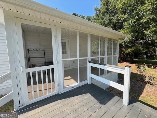 back of property featuring a deck and a lawn