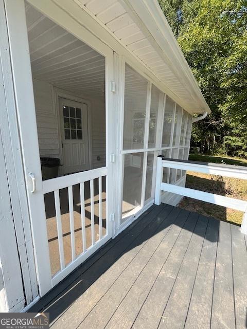 rear view of property featuring a wooden deck and a yard