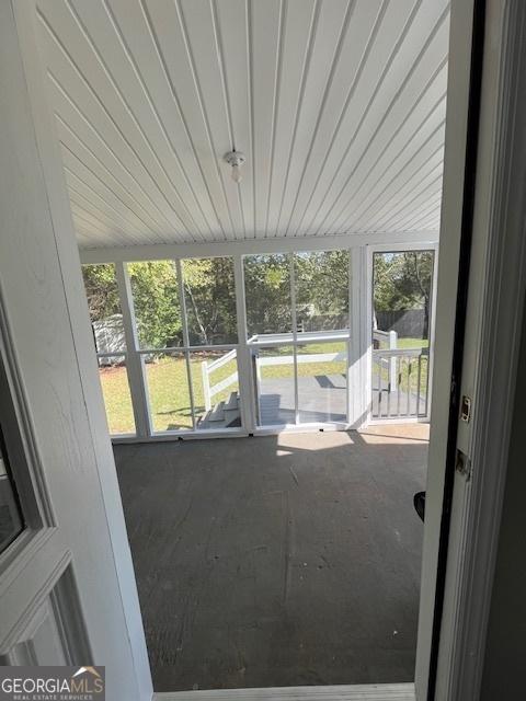 view of side of home featuring a wooden deck, central AC, and a yard