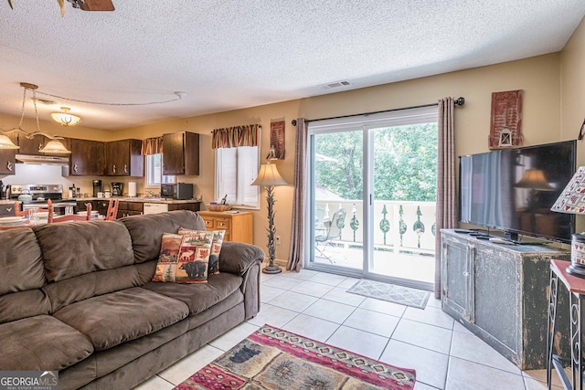 tiled living room featuring a textured ceiling and ceiling fan