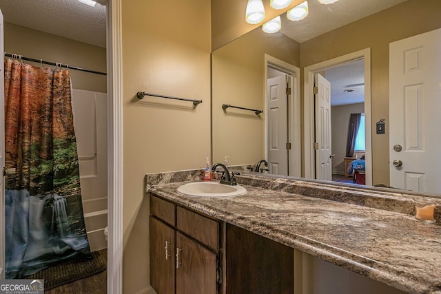 bathroom featuring vanity, a shower with curtain, and a textured ceiling