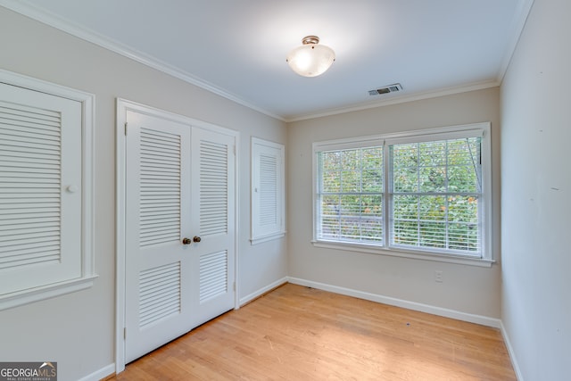 unfurnished bedroom featuring light wood-type flooring and ornamental molding