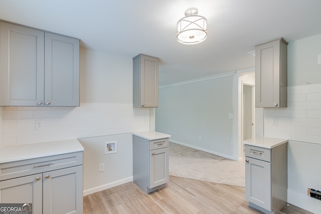 kitchen with gray cabinetry, decorative backsplash, and light hardwood / wood-style flooring