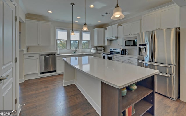 kitchen with appliances with stainless steel finishes, white cabinets, dark wood-type flooring, and a kitchen island