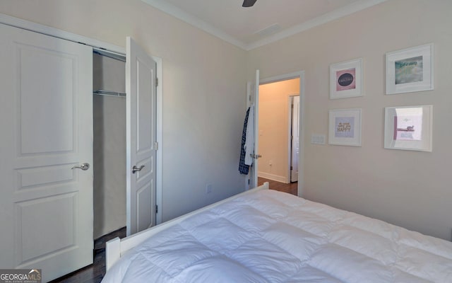 bedroom with crown molding, dark hardwood / wood-style floors, a closet, and ceiling fan