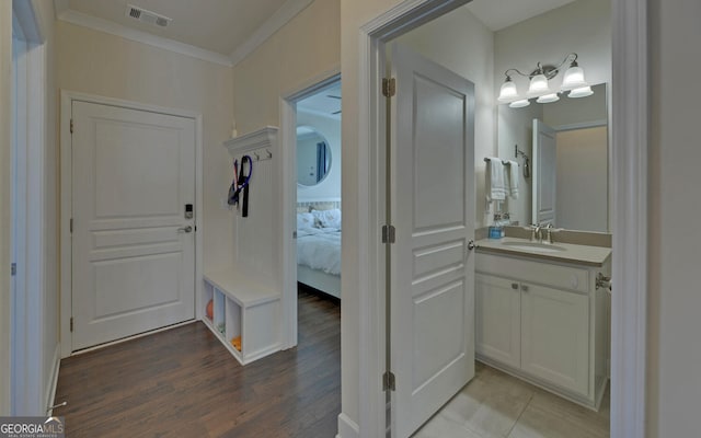 interior space featuring vanity, crown molding, and hardwood / wood-style flooring