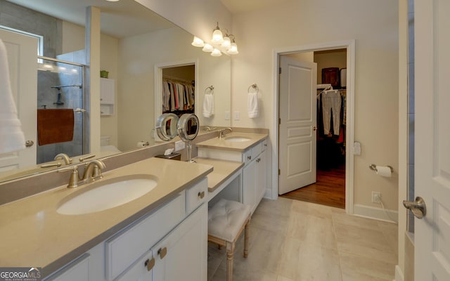 bathroom featuring a shower with door, vanity, toilet, and tile patterned flooring