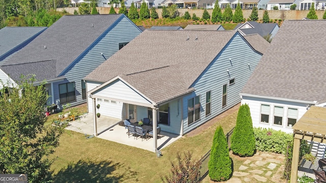 rear view of house featuring a patio area and a yard