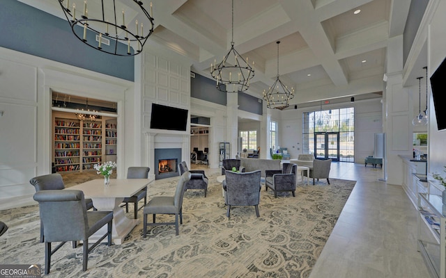 dining space featuring coffered ceiling, beamed ceiling, a high ceiling, and built in shelves