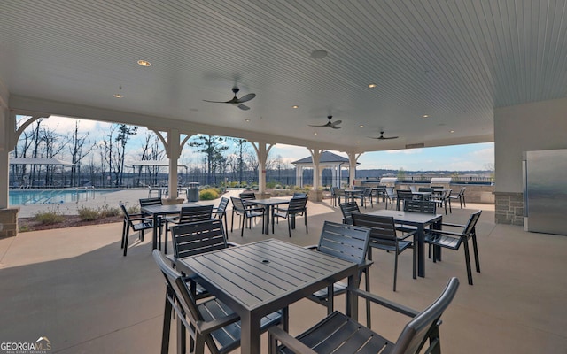 view of patio featuring ceiling fan and a community pool