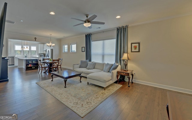 living room with crown molding, dark hardwood / wood-style flooring, and ceiling fan with notable chandelier