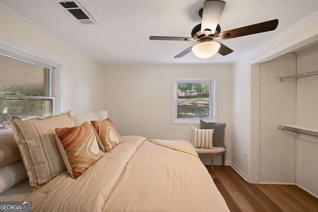 bedroom featuring hardwood / wood-style flooring, ceiling fan, a textured ceiling, and a closet