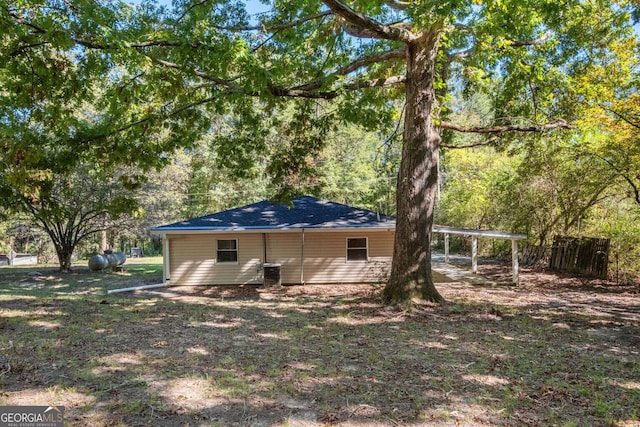 back of house featuring a carport