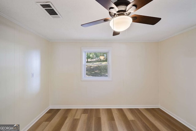 spare room featuring hardwood / wood-style flooring, ceiling fan, and crown molding