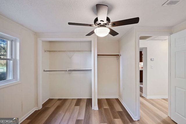 unfurnished bedroom with ceiling fan, hardwood / wood-style floors, and a textured ceiling