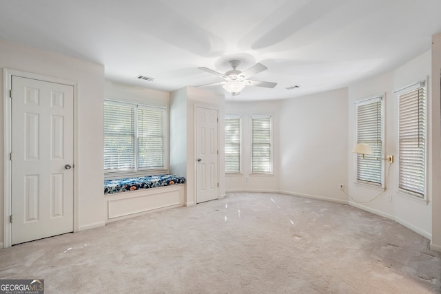 carpeted spare room featuring ceiling fan