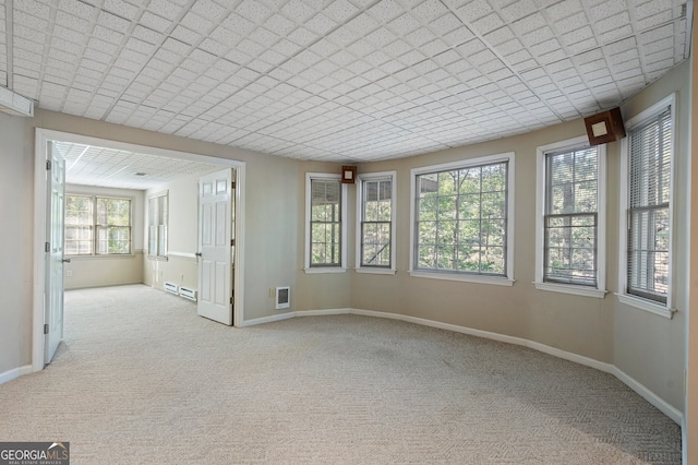 carpeted empty room with a baseboard radiator