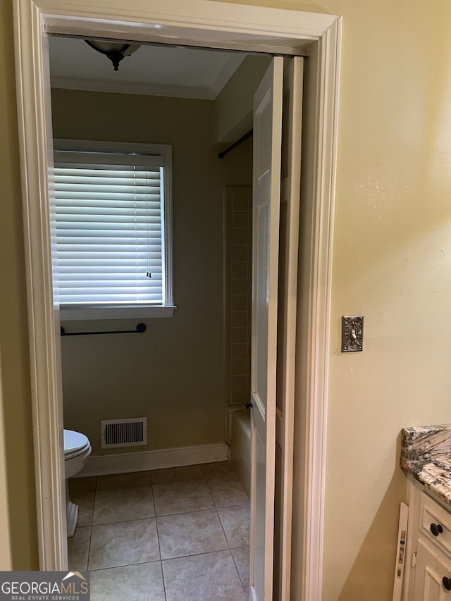 bathroom with toilet, ornamental molding, vanity, and tile patterned floors