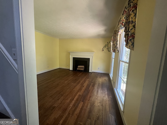 unfurnished living room with ornamental molding and dark hardwood / wood-style flooring