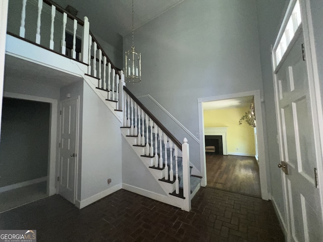 stairs with an inviting chandelier and a high ceiling