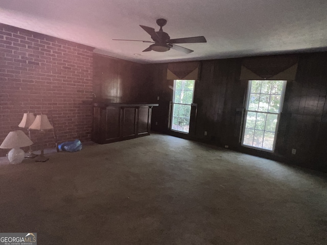 unfurnished living room featuring a textured ceiling, carpet floors, and ceiling fan