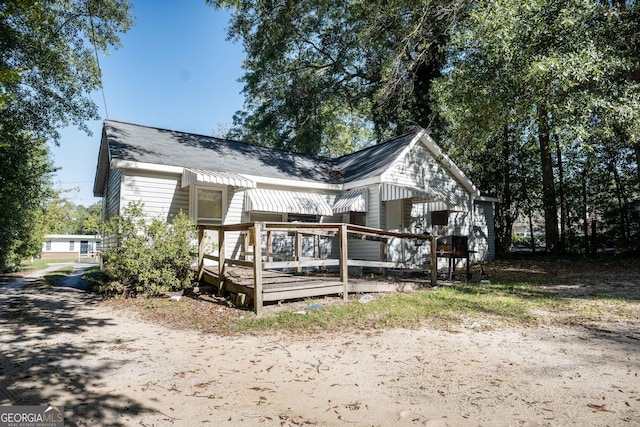 rear view of house featuring a wooden deck