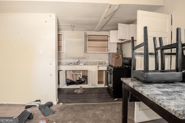 kitchen with white cabinetry, a textured ceiling, dark wood-type flooring, black range with gas cooktop, and sink