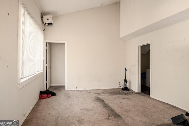 carpeted empty room featuring a high ceiling