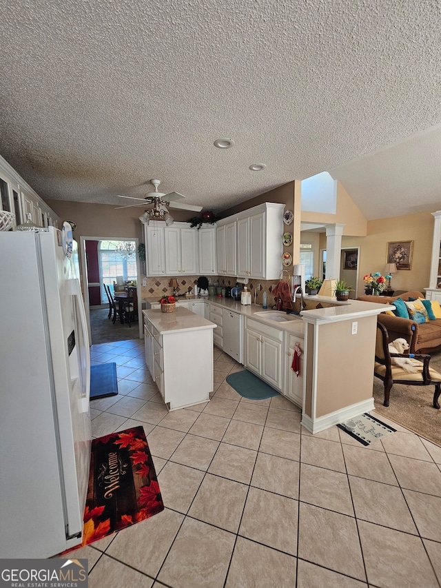 kitchen featuring kitchen peninsula, ceiling fan, a kitchen island, white cabinetry, and white refrigerator with ice dispenser