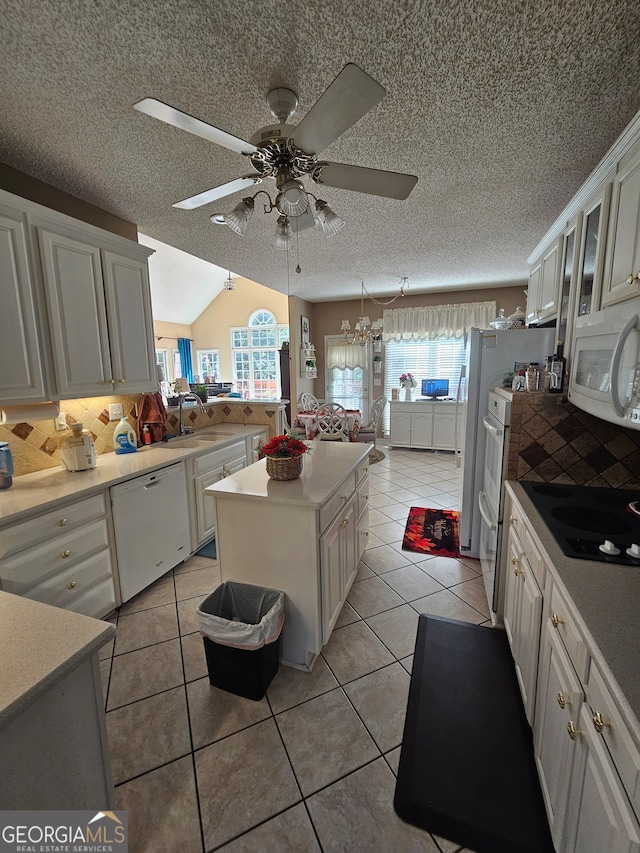 kitchen with a wealth of natural light, white appliances, and light tile patterned floors