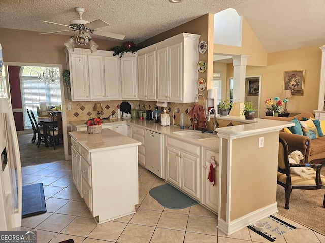 kitchen featuring kitchen peninsula, sink, a center island, light tile patterned floors, and a textured ceiling