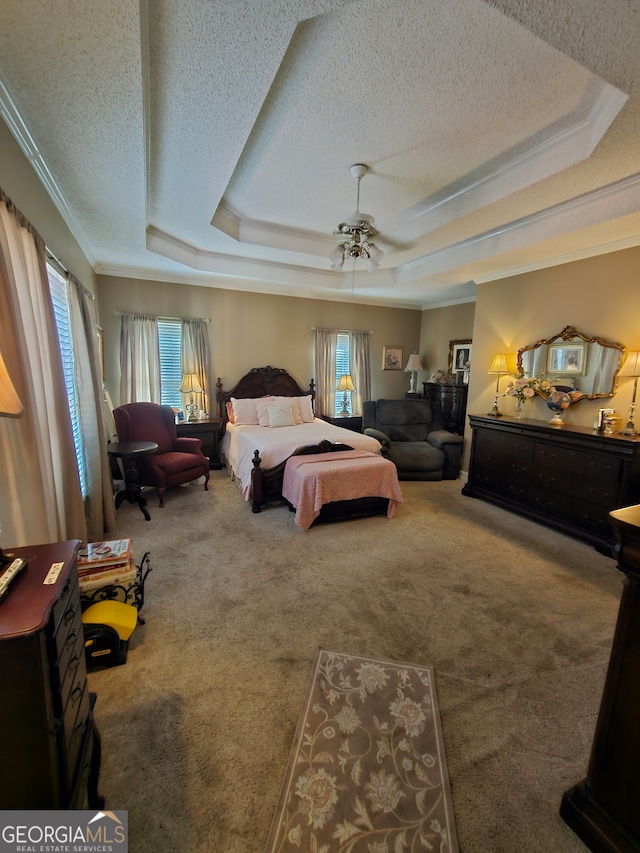 carpeted bedroom featuring ceiling fan, a raised ceiling, a textured ceiling, and crown molding