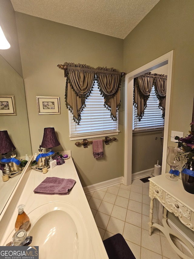 bathroom with vanity, a textured ceiling, and tile patterned flooring