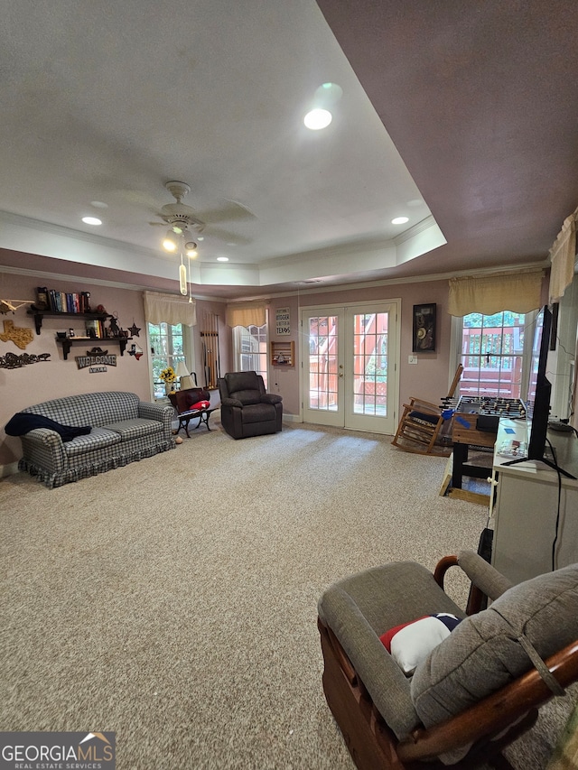 carpeted living room featuring a textured ceiling, a tray ceiling, french doors, and ceiling fan