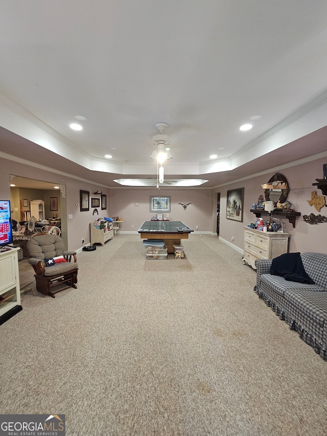 recreation room with crown molding, carpet flooring, a raised ceiling, and ceiling fan