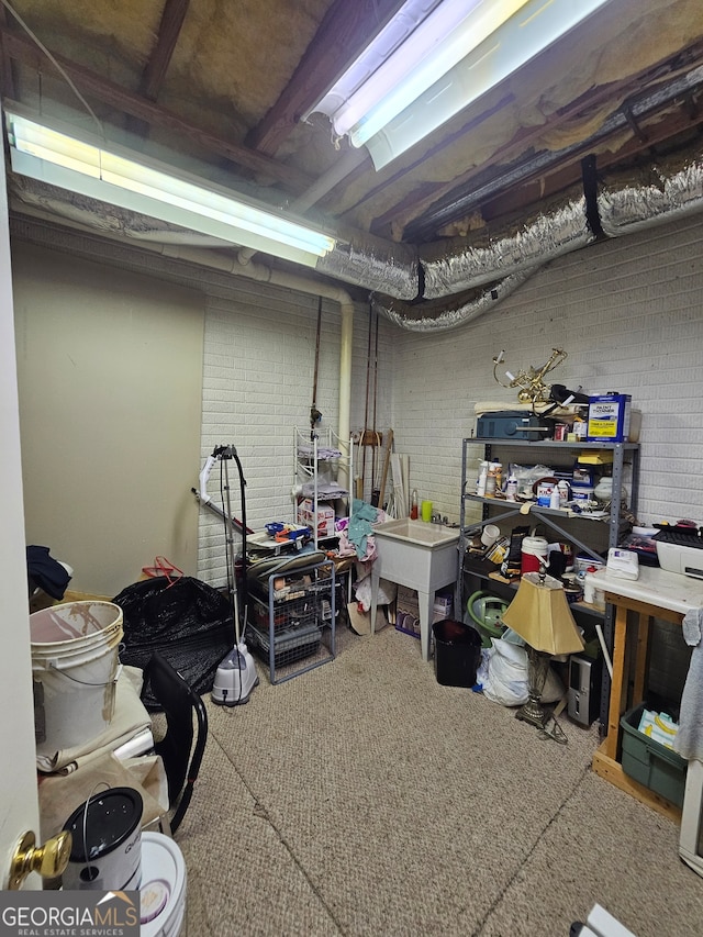 basement with carpet floors and brick wall